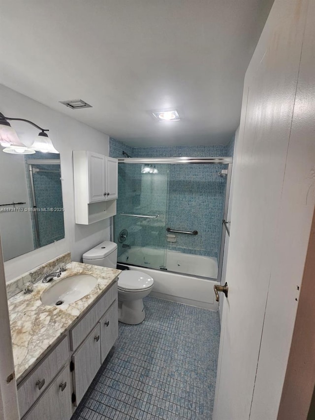 full bathroom with vanity, tile patterned flooring, shower / bath combination with glass door, and toilet