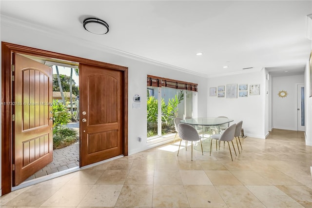 entrance foyer featuring crown molding, light tile patterned flooring, a healthy amount of sunlight, and baseboards