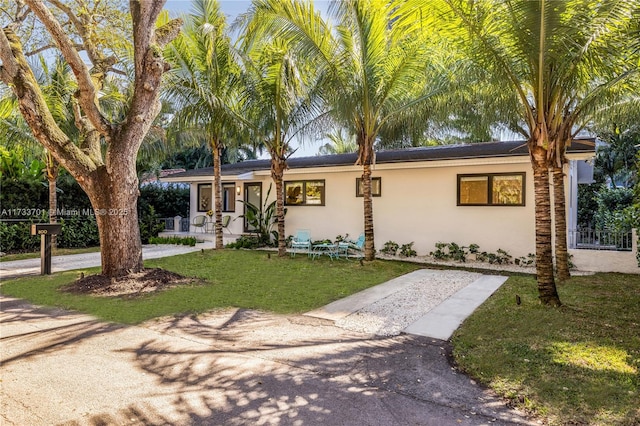 ranch-style house featuring a porch and a front lawn