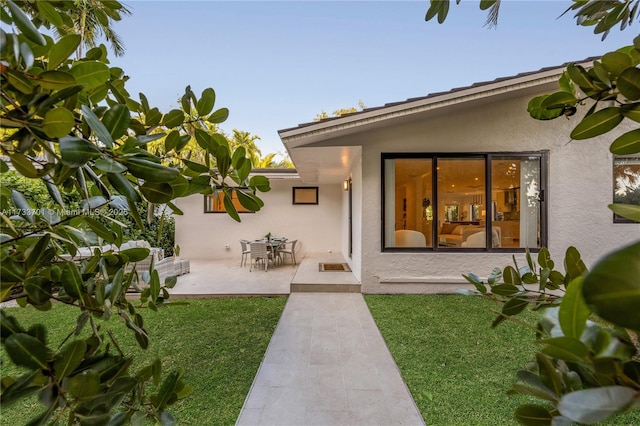 rear view of property with a yard and a patio area