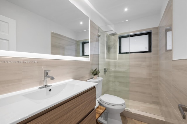 bathroom with tile walls, vanity, tasteful backsplash, a tile shower, and toilet