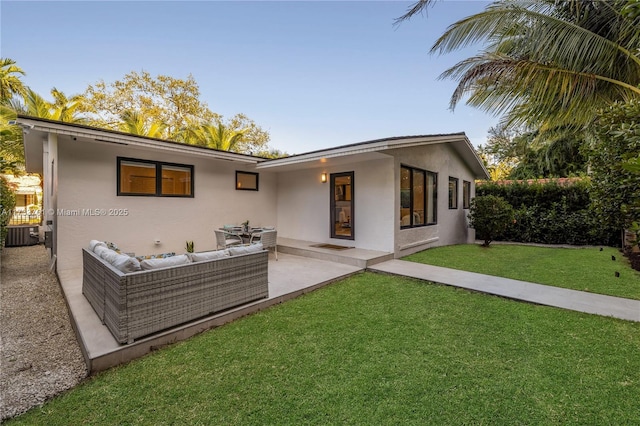 rear view of property featuring central AC unit, a yard, and outdoor lounge area