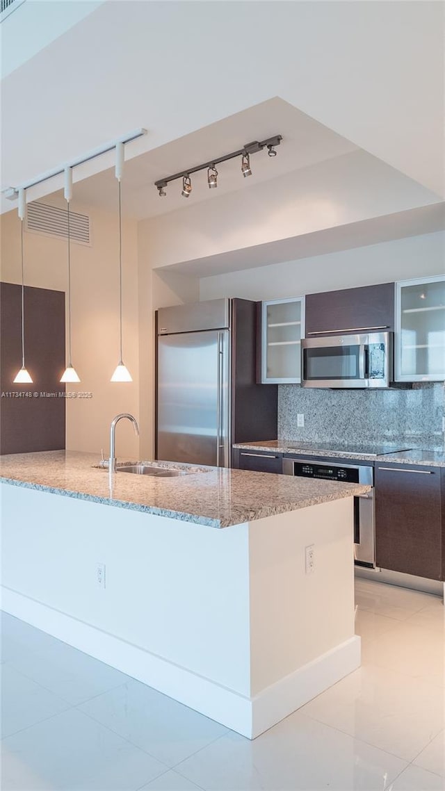 kitchen featuring light stone counters, hanging light fixtures, tasteful backsplash, and appliances with stainless steel finishes