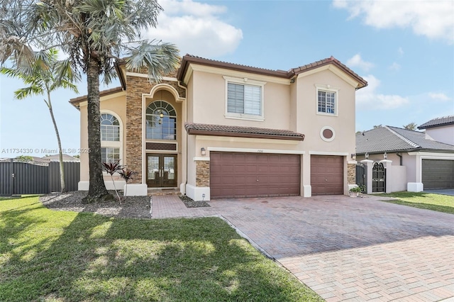 mediterranean / spanish-style home featuring a garage, a front yard, and french doors