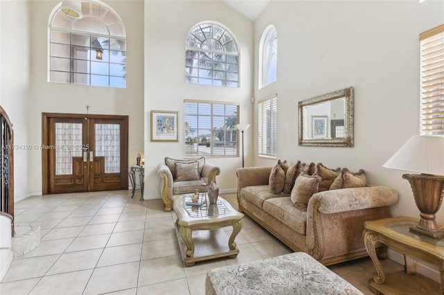 tiled living room featuring a towering ceiling, a healthy amount of sunlight, and french doors