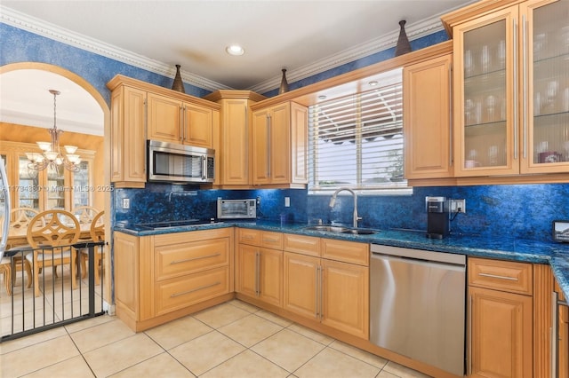 kitchen featuring ornamental molding, appliances with stainless steel finishes, sink, and dark stone counters