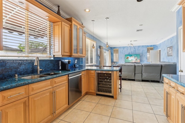 kitchen with pendant lighting, sink, wine cooler, ornamental molding, and stainless steel dishwasher