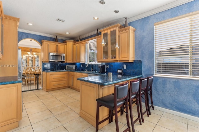 kitchen featuring crown molding, pendant lighting, and kitchen peninsula