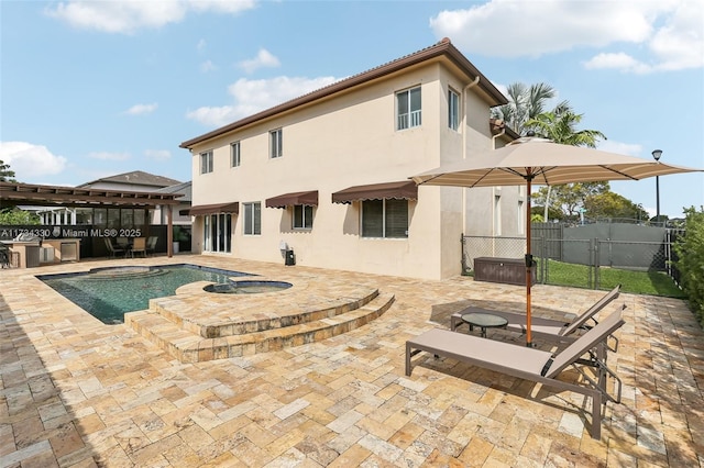 back of property featuring a swimming pool with hot tub and a patio area