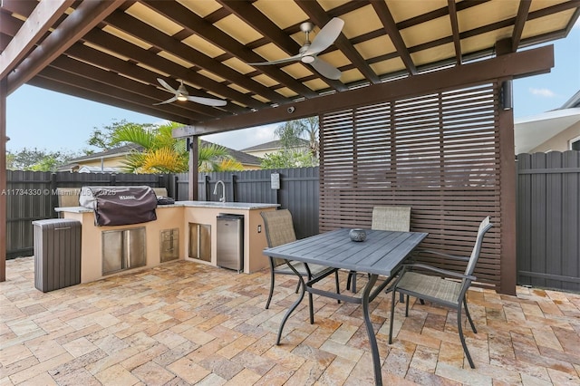 view of patio / terrace with ceiling fan, exterior kitchen, sink, and area for grilling