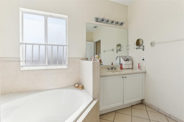 bathroom featuring a relaxing tiled tub, vanity, and tile patterned flooring