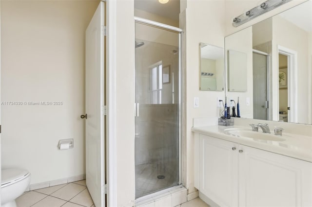 bathroom featuring a shower with door, vanity, tile patterned floors, and toilet