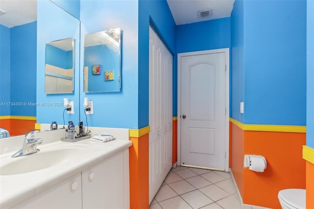 bathroom featuring tile patterned flooring, vanity, and toilet