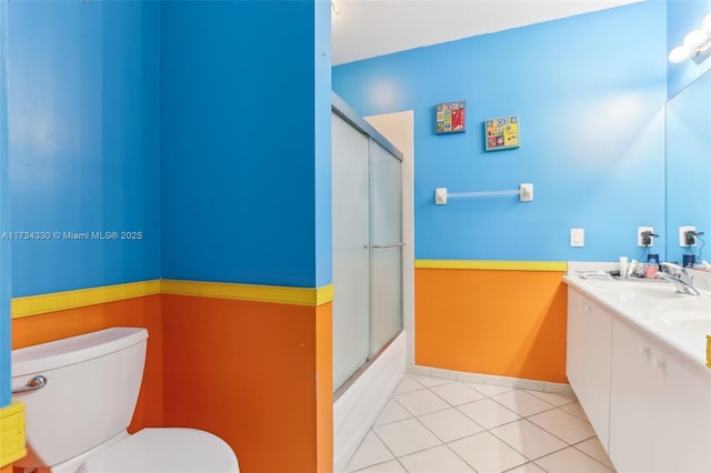 full bathroom with bath / shower combo with glass door, vanity, toilet, and tile patterned flooring