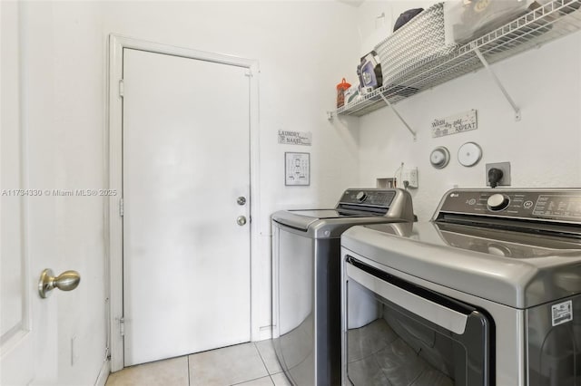 laundry area with independent washer and dryer and light tile patterned flooring