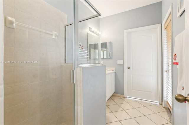 bathroom with tile patterned flooring, vanity, and a shower with door