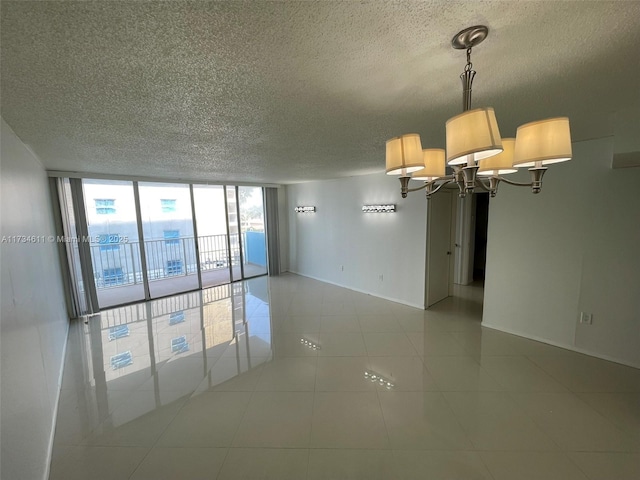 5838 Collins Ave Unit 3D, Miami Beach, FL 33140 - spare room with a textured ceiling, a chandelier, floor to ceiling windows, and tile patterned flooring
