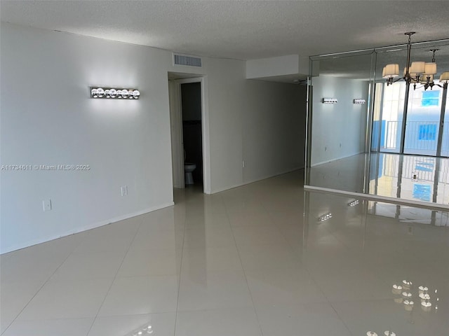 5838 Collins Ave Unit 3D, Miami Beach, FL 33140 - spare room featuring a textured ceiling and a chandelier
