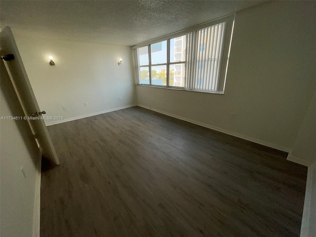 5838 Collins Ave Unit 3D, Miami Beach, FL 33140 - unfurnished room with dark wood-type flooring and a textured ceiling
