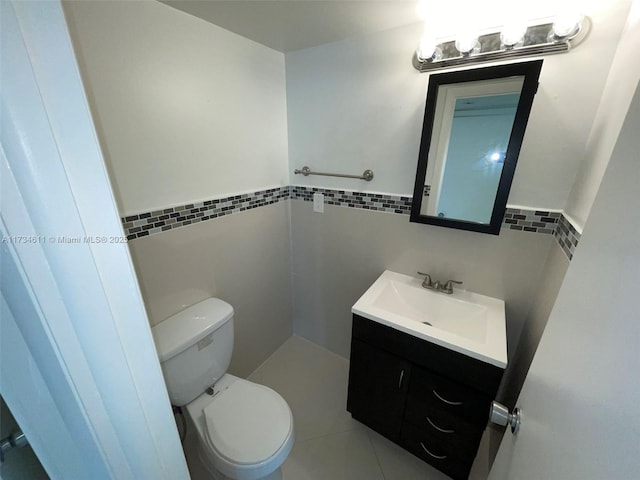 5838 Collins Ave Unit 3D, Miami Beach, FL 33140 - half bathroom featuring tile walls, vanity, a wainscoted wall, and tile patterned flooring