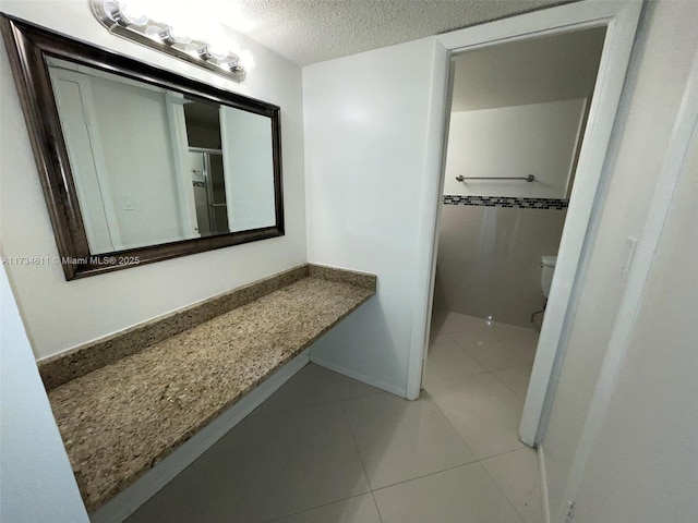 5838 Collins Ave Unit 3D, Miami Beach, FL 33140 - bathroom with a textured ceiling, tile patterned flooring, vanity, and a shower