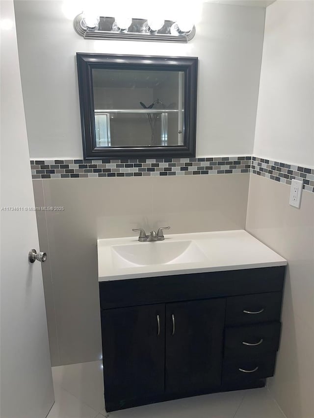 bathroom featuring tile patterned floors, vanity, and tile walls