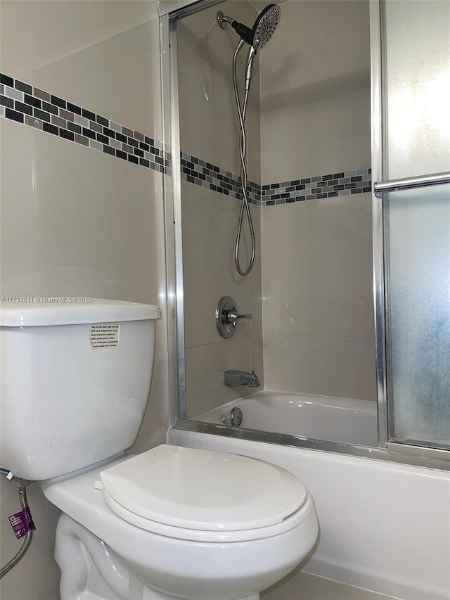 bathroom with tiled shower / bath and toilet