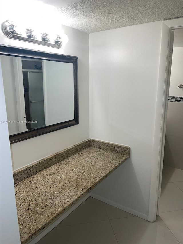 bathroom featuring tile patterned floors and a textured ceiling