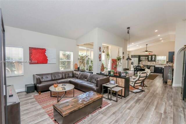 dining area with ceiling fan, sink, high vaulted ceiling, and light wood-type flooring