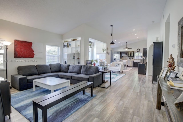 living room featuring high vaulted ceiling and light hardwood / wood-style flooring