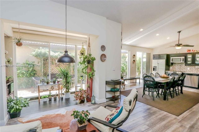 dining space with lofted ceiling, ceiling fan, and light hardwood / wood-style flooring