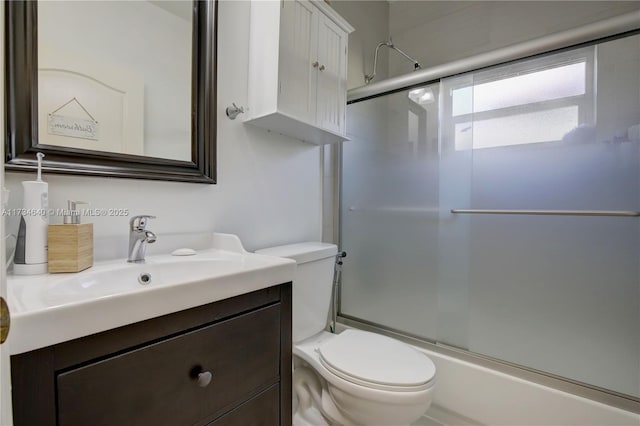 full bathroom with vanity, toilet, and combined bath / shower with glass door