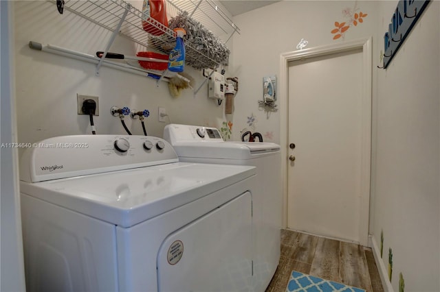 clothes washing area featuring separate washer and dryer and hardwood / wood-style flooring