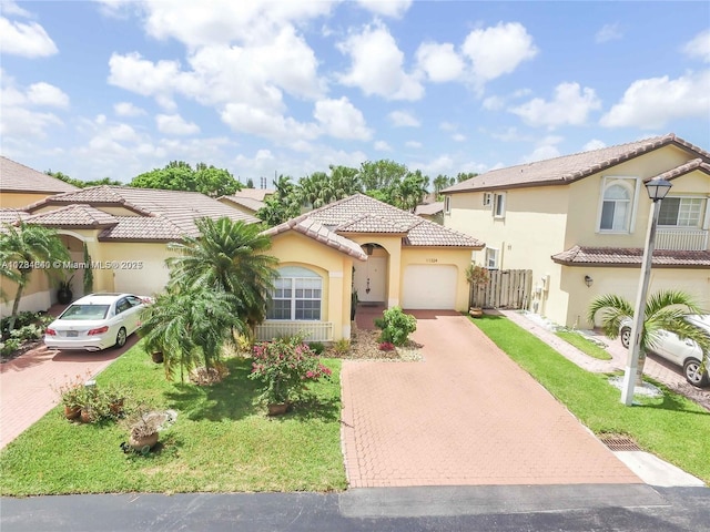 mediterranean / spanish home with a garage and a front yard