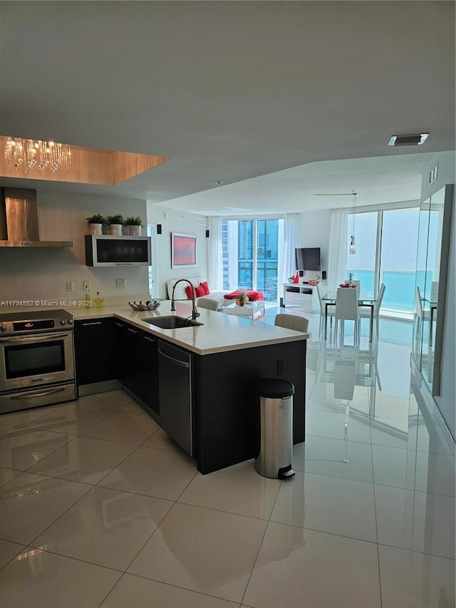 kitchen with black dishwasher, sink, electric range, kitchen peninsula, and wall chimney exhaust hood