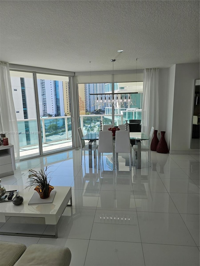 tiled dining room featuring plenty of natural light, floor to ceiling windows, and a textured ceiling