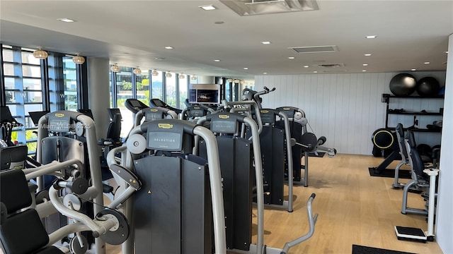 workout area with light hardwood / wood-style flooring