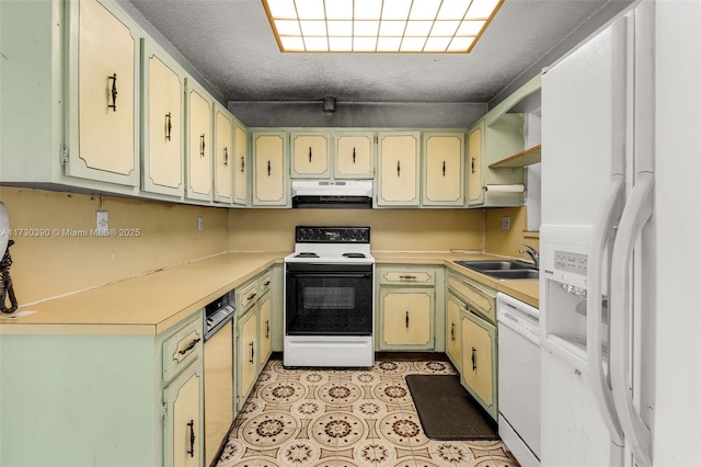 kitchen featuring sink, white appliances, a textured ceiling, and green cabinets