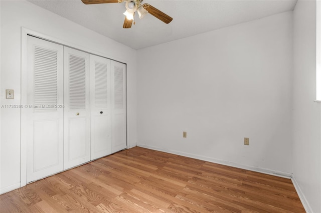 unfurnished bedroom featuring ceiling fan, a closet, and light hardwood / wood-style flooring