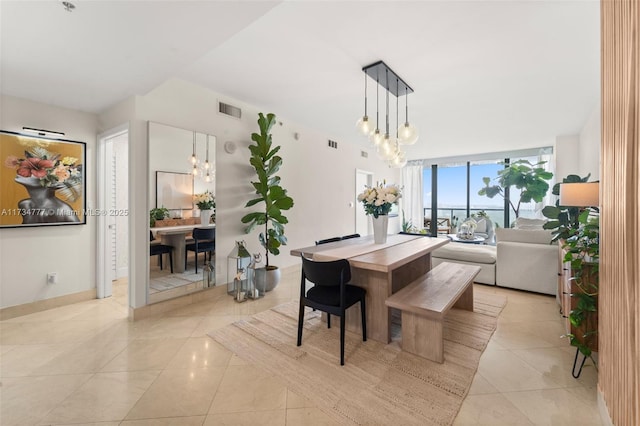 dining room featuring light tile patterned floors, a wall of windows, and a chandelier