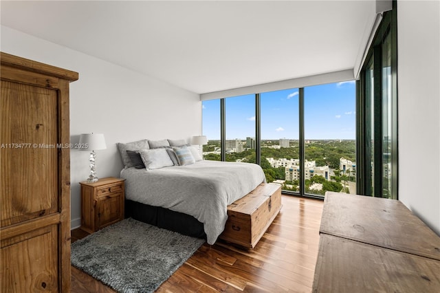 bedroom featuring hardwood / wood-style floors and a wall of windows