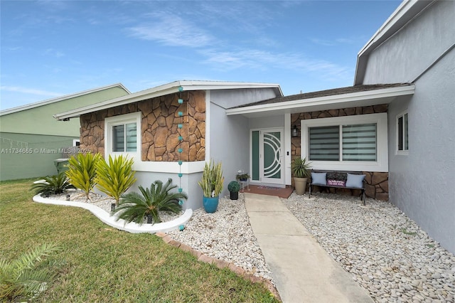 view of exterior entry featuring a lawn