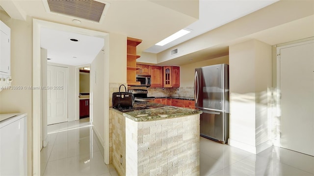 kitchen with sink, appliances with stainless steel finishes, backsplash, light tile patterned flooring, and kitchen peninsula