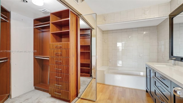 bathroom featuring hardwood / wood-style flooring, vanity, and a bathtub