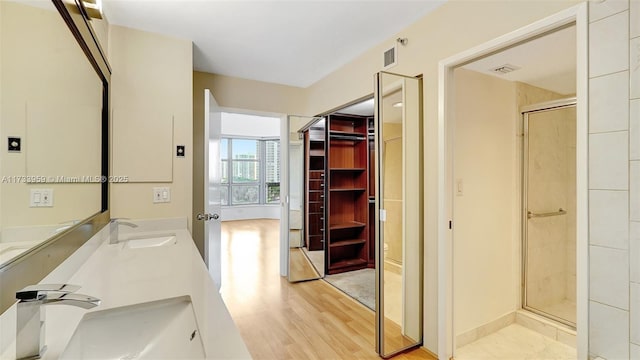 bathroom with a shower with door, wood-type flooring, and vanity