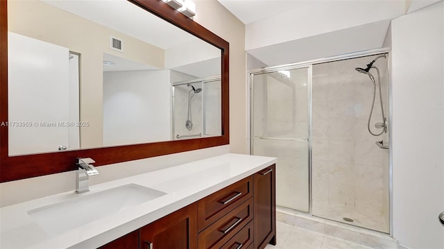 bathroom with vanity, an enclosed shower, and tile patterned flooring