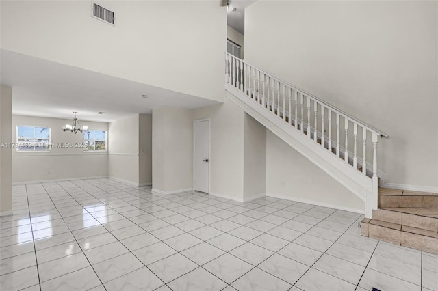 staircase with tile patterned flooring, a high ceiling, and a notable chandelier