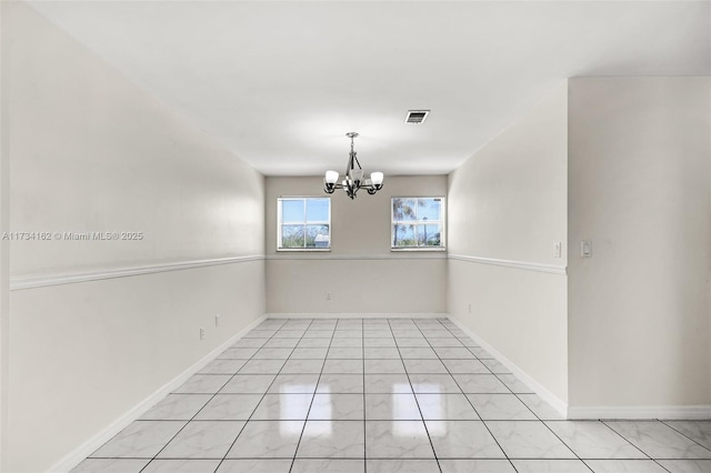 spare room featuring a chandelier