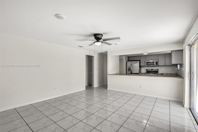 unfurnished living room featuring sink and ceiling fan