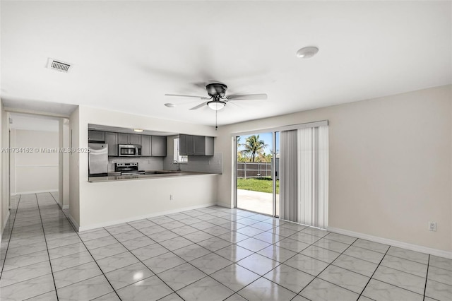 unfurnished living room with light tile patterned floors, sink, and ceiling fan